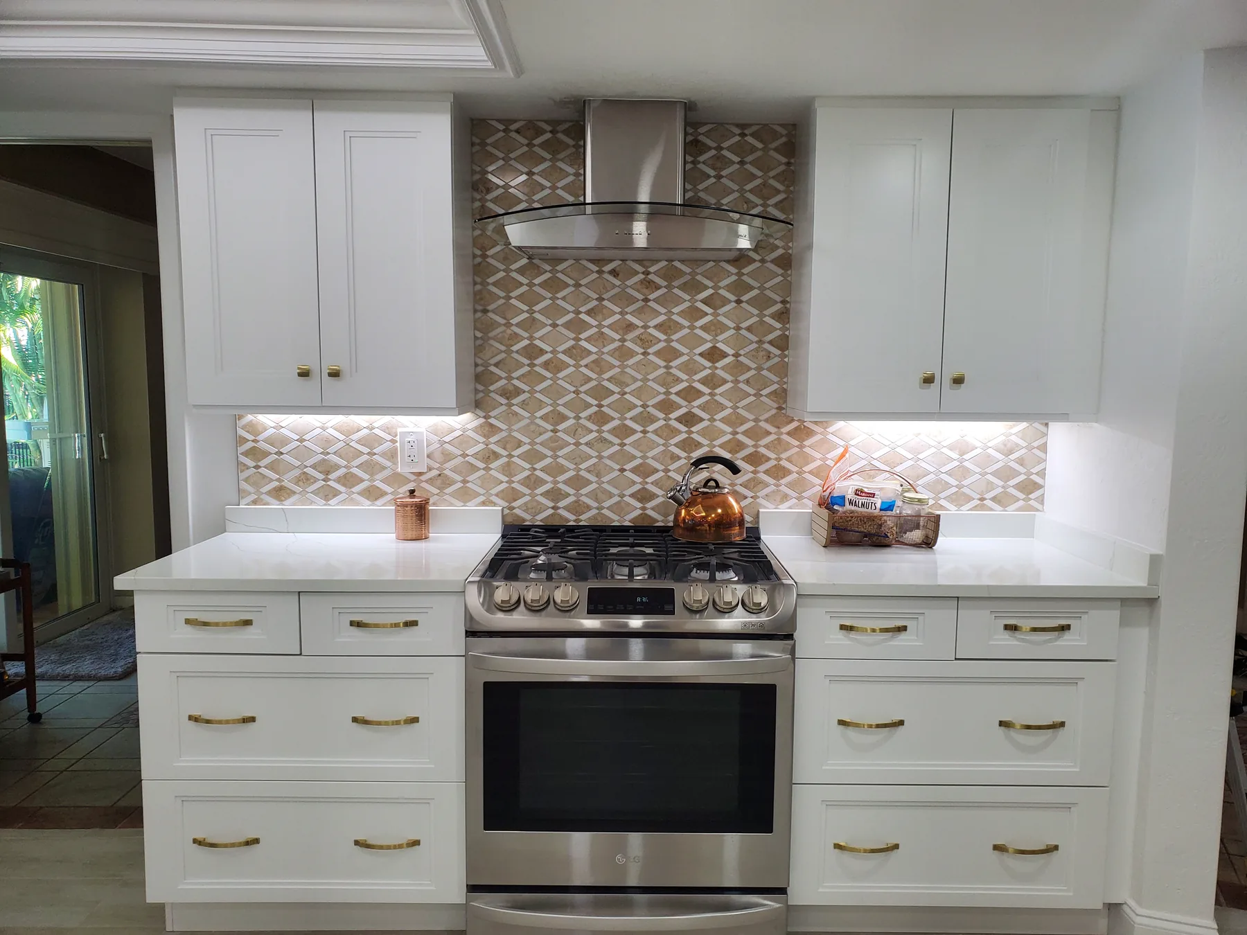 Bright white remodeled kitchen with gold hardware completed by Stallions Construction